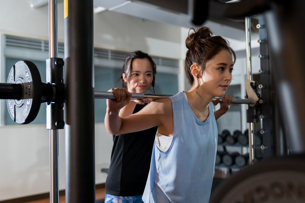 A woman training with guidance from a trainer